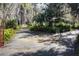 Long driveway leading to a charming house nestled amongst lush trees and landscaping at 3751 Se 3Rd Ave, Ocala, FL 34471