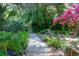 Meandering stone path through lush landscaping, showcasing vibrant flowers and ferns at 3751 Se 3Rd Ave, Ocala, FL 34471