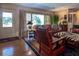 Spacious living room with hardwood floors, leather furniture, and large windows at 3751 Se 3Rd Ave, Ocala, FL 34471