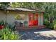 Inviting studio with red doors, a deck, and lush landscaping at 3751 Se 3Rd Ave, Ocala, FL 34471