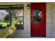 Red front door with glass panels and sidelights welcomes guests to the home at 3751 Se 3Rd Ave, Ocala, FL 34471