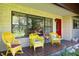 Inviting front porch features yellow wicker rocking chairs and a red front door at 3751 Se 3Rd Ave, Ocala, FL 34471