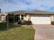 House exterior featuring a two-car garage and landscaped lawn at 610 Grand Vista Trl, Leesburg, FL 34748
