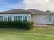 Home's back features a sunroom and a spacious patio area at 610 Grand Vista Trl, Leesburg, FL 34748