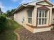 Exterior side view showcasing a large window and landscaping at 610 Grand Vista Trl, Leesburg, FL 34748
