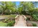 Wooden footbridge over tranquil stream leading to pool area at 2162 Se Mill Creek Cir, Ocala, FL 34471