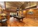 Spacious game room with a pool table, hardwood floors, and wood-paneled walls at 2162 Se Mill Creek Cir, Ocala, FL 34471