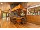 Rustic wet bar with wood cabinets, stone accents, and a stained glass window at 2162 Se Mill Creek Cir, Ocala, FL 34471