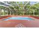 Screened pool with brick patio and lush landscaping at 7086 Se 12Th Cir, Ocala, FL 34480