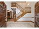 Grand entryway with tiled floor, wooden staircase, and double doors at 7086 Se 12Th Cir, Ocala, FL 34480