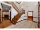 Elegant entryway showcasing a hardwood floor and a wooden staircase at 7086 Se 12Th Cir, Ocala, FL 34480