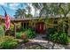 Home's entrance with red door and landscaping at 735 Se 22Nd Ave, Ocala, FL 34471