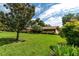 House with large tree in foreground, expansive lawn at 735 Se 22Nd Ave, Ocala, FL 34471