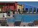 Inviting community pool with surrounding lounge chairs and colorful buildings at 5598 Sw 39Th St, Ocala, FL 34474