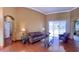 Living room with hardwood floors, leather furniture, and large windows at 9029 Laurel Ridge Dr, Mount Dora, FL 32757