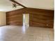 Spacious living room with wood wall paneling and tile floors at 12351 Se 114Th St, Ocklawaha, FL 32179