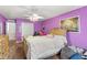 Purple bedroom with double bed, wood dresser, and ceiling fan at 8083 Se 62Nd Loop, Ocala, FL 34472