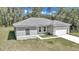 Newly constructed one-story home with gray siding, a white garage door, and a well-manicured lawn at 6839 Sw 149Th Lane Rd, Ocala, FL 34473