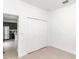 Spacious bedroom with white walls, tile floors, and a double-door closet, kitchen view at 6839 Sw 149Th Lane Rd, Ocala, FL 34473