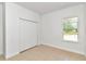Simple bedroom with white walls, tile floors, and a double-door closet at 6839 Sw 149Th Lane Rd, Ocala, FL 34473