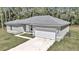 Newly built single-story house with gray siding, white garage door, and a neat lawn at 6839 Sw 149Th Lane Rd, Ocala, FL 34473