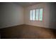 Spacious bedroom with neutral carpeting and window at 5038 Se 6Th Ave, Ocala, FL 34480