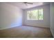 Spacious bedroom with neutral carpeting and large window at 5038 Se 6Th Ave, Ocala, FL 34480
