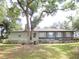 House rear view, showcasing a screened porch and lush greenery at 16789 Se 69Th Ln, Ocklawaha, FL 32179