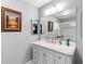Bright bathroom with vanity, large mirror, and shower at 612 Fannich Ct, Leesburg, FL 34788