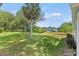Large backyard with lush green grass and mature trees at 612 Fannich Ct, Leesburg, FL 34788