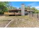 Home's back features a deck, chimney, and fenced backyard at 8975 Sw 202Nd Avenue Rd, Dunnellon, FL 34431