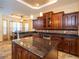 Spacious kitchen with dark wood cabinets, granite counters, and stainless steel appliances at 1719 Sw 27Th Pl, Ocala, FL 34471