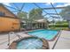 Large screened pool with adjacent spa and patio area at 2811 Se 14Th St, Ocala, FL 34471