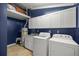 Bright laundry room with white cabinets, washer, dryer, and utility sink at 2811 Se 14Th St, Ocala, FL 34471