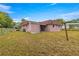 Rear view of a pink house with a patio and yard at 46 Lake Court Loop, Ocala, FL 34472