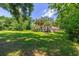 Large grassy backyard with mature trees and partial home view at 5240 Se 17Th St, Ocala, FL 34471
