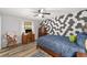 Bedroom with a wood bed frame, geometric accent wall, and wood dresser at 5240 Se 17Th St, Ocala, FL 34471