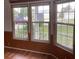 Bright living room with bay windows, wood flooring and wood paneling at 24822 Pine Hl, Leesburg, FL 34748