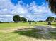 Golf course view with players and carts on a partly cloudy day at 16026 Sw 14Th Avenue Rd, Ocala, FL 34473