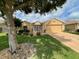 House with manicured lawn, landscaping, and a large tree at 16026 Sw 14Th Avenue Rd, Ocala, FL 34473