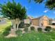 House with manicured lawn, landscaping, and a large tree at 16026 Sw 14Th Avenue Rd, Ocala, FL 34473