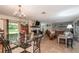 Open concept dining room with glass table and view into living room at 15669 Se 112Th Ln, Ocklawaha, FL 32179