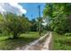 Long driveway leading through a lush green landscape at 15669 Se 112Th Ln, Ocklawaha, FL 32179