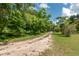 Long driveway leading to a home nestled amongst lush greenery at 15669 Se 112Th Ln, Ocklawaha, FL 32179