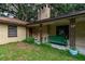Quaint front porch with a green bench and decorative planters at 15669 Se 112Th Ln, Ocklawaha, FL 32179