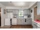 Kitchen with gray cabinets, dishwasher, and window overlooking backyard at 15669 Se 112Th Ln, Ocklawaha, FL 32179