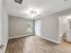 Bedroom with wood-look floors, ceiling fan, and access to bathroom at 13359 Sw 80Th St, Dunnellon, FL 34432