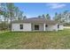 White house exterior with covered patio and grassy yard at 13359 Sw 80Th St, Dunnellon, FL 34432