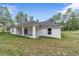 White house exterior with covered patio and grassy yard at 13359 Sw 80Th St, Dunnellon, FL 34432