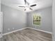Bright bedroom with ceiling fan, wood-look flooring, and window with wooded view at 10020 Sw 202Nd Cir, Dunnellon, FL 34431